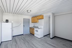Carbondale apartment for rent - A kitchen with a white refrigerator, white stove, and wooden cabinets.