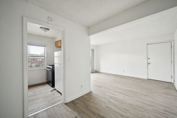 Detroit apartment for rent - A kitchen with white cabinets and a window overlooking a cityscape.