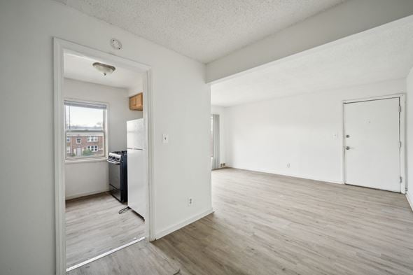 Detroit apartment for rent - A kitchen with white cabinets and a window overlooking a cityscape.