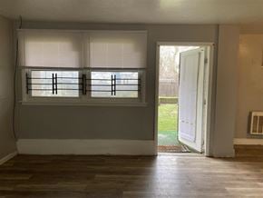 Philadelphia apartment for rent - A room with a window covered by white blinds and a door open to a backyard.