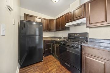 Atlantic City apartment for rent - a kitchen with black appliances and wooden cabinets