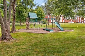 Indianapolis apartment for rent - a playground with a swing set and slides in a park
