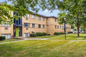 Indianapolis apartment for rent - a large brick apartment building with green grass and trees