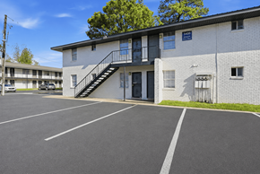 Memphis apartment for rent - A parking lot in front of a white building with a black staircase.