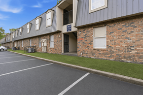 Memphis apartment for rent - A parking lot in front of a brick building with a blue sign that says "No Parking".