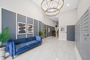 Philadelphia apartment for rent - A blue sofa sits in a spacious room with a chandelier hanging from the ceiling.