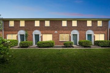 Columbus apartment for rent - A red brick building with green doors and windows.