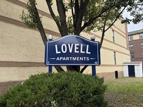 Philadelphia apartment for rent - A blue sign that says Lovell Apartments stands in front of a building.