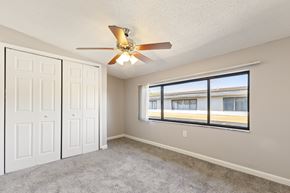 Tampa apartment for rent - A room with a ceiling fan and a window overlooking a building.