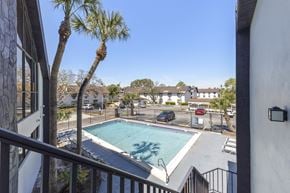 Tampa apartment for rent - A pool surrounded by a fence and a few trees.