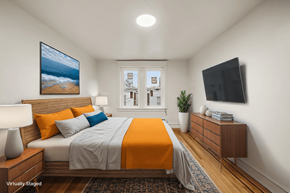 Philadelphia apartment for rent - A bedroom with a bed, a nightstand, a lamp, a plant, and a painting on the wall.