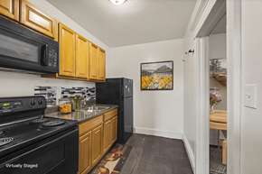 Philadelphia apartment for rent - A kitchen with wooden cabinets and black appliances.