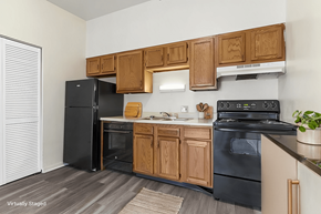 Saint Louis apartment for rent - A kitchen with black appliances and wooden cabinets.