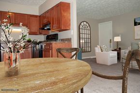 Indianapolis apartment for rent - A kitchen with brown cabinets and a wooden table.
