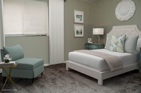Indianapolis apartment for rent - A bedroom with a large bed and a small chair.