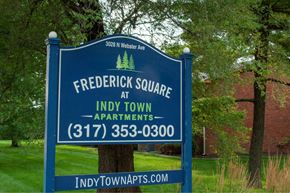 Indianapolis apartment for rent - A sign for Frederick Square at Indy Town Apartments stands in front of a tree.