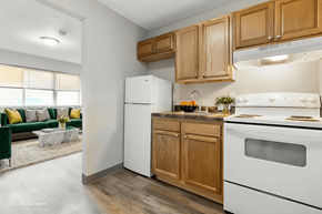 Carbondale apartment for rent - A kitchen with a white refrigerator and white stove with wooden cabinets.