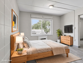 Carbondale apartment for rent - A bedroom with a bed, nightstand, and a window with a view of trees.