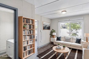 Carbondale apartment for rent - A living room with a white couch, a wooden bookshelf, and a rug.