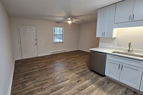 Greenville apartment for rent - an empty kitchen and living room with a ceiling fan