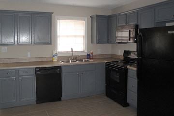 Greenville apartment for rent - a kitchen with black appliances and blue cabinets