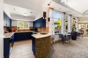 Bremerton apartment for rent - a kitchen with blue cabinets and a table with chairs