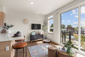 Kent apartment for rent - A modern kitchen with a bar stool and a table with a potted plant on it.