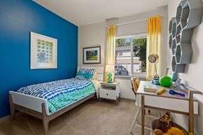 Covington apartment for rent - A bedroom with blue walls and a bed with a blue and white comforter.