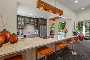 Covington apartment for rent - A kitchen with a bar area and a refrigerator.