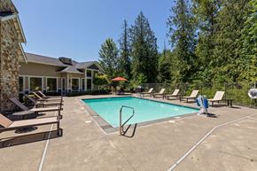 Covington apartment for rent - A swimming pool surrounded by lounge chairs and trees.