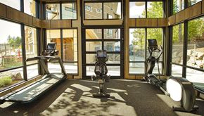 Maple Valley apartment for rent - a gym with exercise equipment and windows with a view of the yard