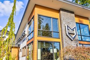 Maple Valley apartment for rent - the front of a building with glass windows and a sign on the side