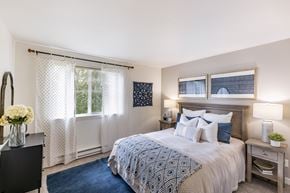 Seattle apartment for rent - A bedroom with a large bed and a window with curtains.