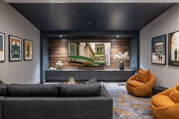 Tacoma apartment for rent - A living room with a grey couch and a large painting of a green landscape.