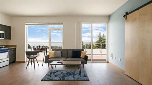Seattle apartment for rent - a living room with a couch and a table and a balcony