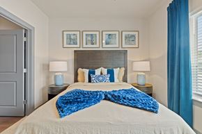 Houston apartment for rent - A bedroom with a large bed and a blue blanket.