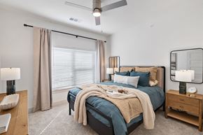 Creedmoor apartment for rent - A bedroom with a large bed and a ceiling fan at Enclave Creedmoor Apartments, Texas, 78610