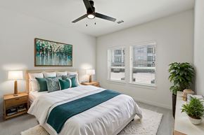 Denton apartment for rent - A bedroom with a large bed and a ceiling fan at Hudson at Pecan Creek Apartments, Texas