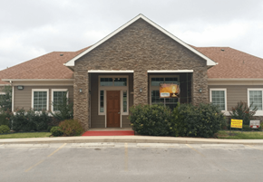Sweetwater apartment for rent - A building with a brown door and a sign in front of it.