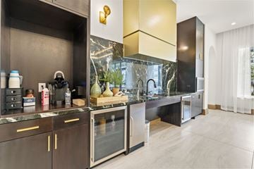 Humble apartment for rent - A modern kitchen with dark wood cabinets and a marble countertop.