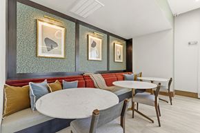 Humble apartment for rent - Dining booth seating with marble tables and artwork at Tapestry Woodland Hills Apartments, Humble, 77346