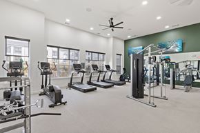 Denton apartment for rent - A spacious gym with a variety of equipment including treadmills, elliptical machines, and weight machines. at Hudson at Pecan Creek Apartments, Denton 76205