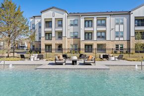 Denton apartment for rent - A modern apartment complex with a pool in front at Hudson at Pecan Creek Apartments, Denton, Texas