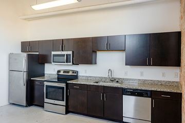 San Antonio apartment for rent - A kitchen with black cabinets and stainless steel appliances.