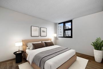Honolulu apartment for rent - A bedroom with a large bed and a potted plant.