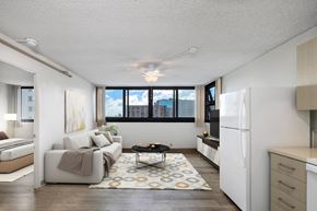 Honolulu apartment for rent - A living room with a couch, a coffee table, and a large window.