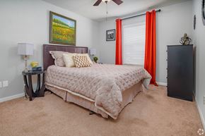 San Antonio apartment for rent - a bedroom with a bed and a window with red curtains