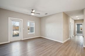 Lockhart apartment for rent - A spacious room with wood flooring and a ceiling fan at Lockhart Farms Apartments, Lockhart, TX, 78644A 
