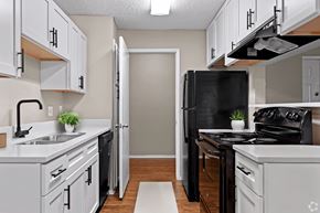 Arlington apartment for rent - a kitchen with white cabinets and a black stove and refrigerator