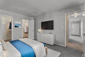 Dallas apartment for rent - a bedroom with a large bed and a tv on the wall